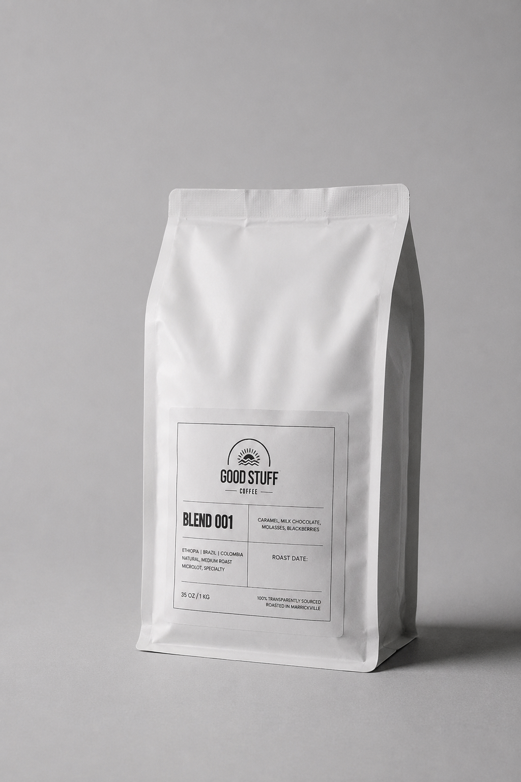 A white stand-up coffee bag with a minimalist black label reading GOOD STUFF and BLEND 001, photographed on a clean light gray background.