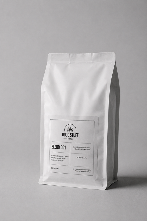 A white stand-up coffee bag with a minimalist black label reading GOOD STUFF and BLEND 001, photographed on a clean light gray background.