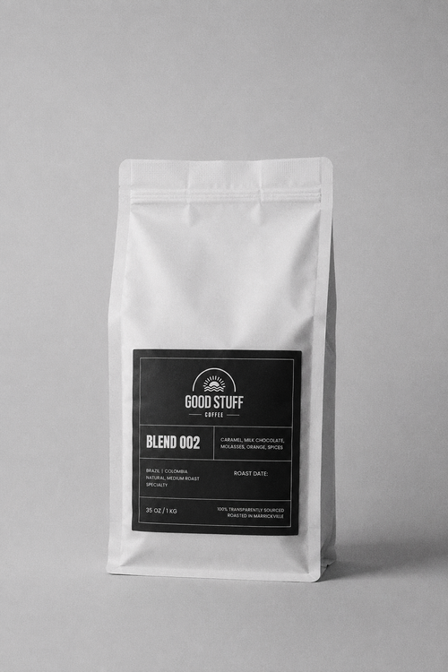 A white stand-up coffee bag with a black front label reading Good Stuff Coffee Blend 002, photographed on a plain light gray background.